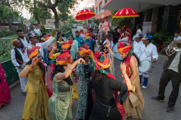 Jodhpur,Rajasthan, India - 19.10.2019 : Baraat. Ladies with wedding turbans,dancing in Joy,happiness for celebration of Sindhi wedding and taking the groom on horse to wedding venue. Sindhi marriage.